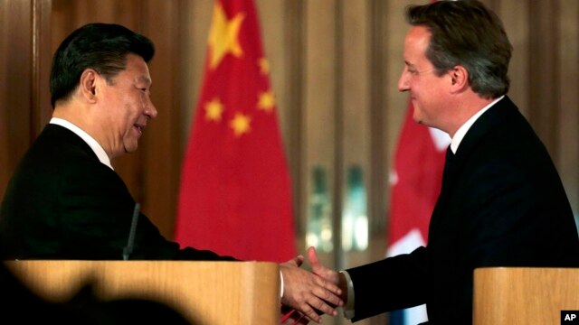 El presidente chino, Xi Jinping (izquierda) estrecha la mano del primer ministro británico, David Cameron durante una conferencia de prensa en Londres, el miércoles 21 de ocutbre de 2015.
