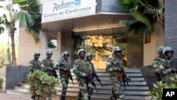 Soldiers from the presidential guard patrol outside the Radisson Blu hotel in Bamako, Mali, in anticipation of the president's visit, Nov. 21, 2015. Islamic extremists armed with guns and grenades stormed the luxury Radisson Blu hotel in Mali's capital Fr