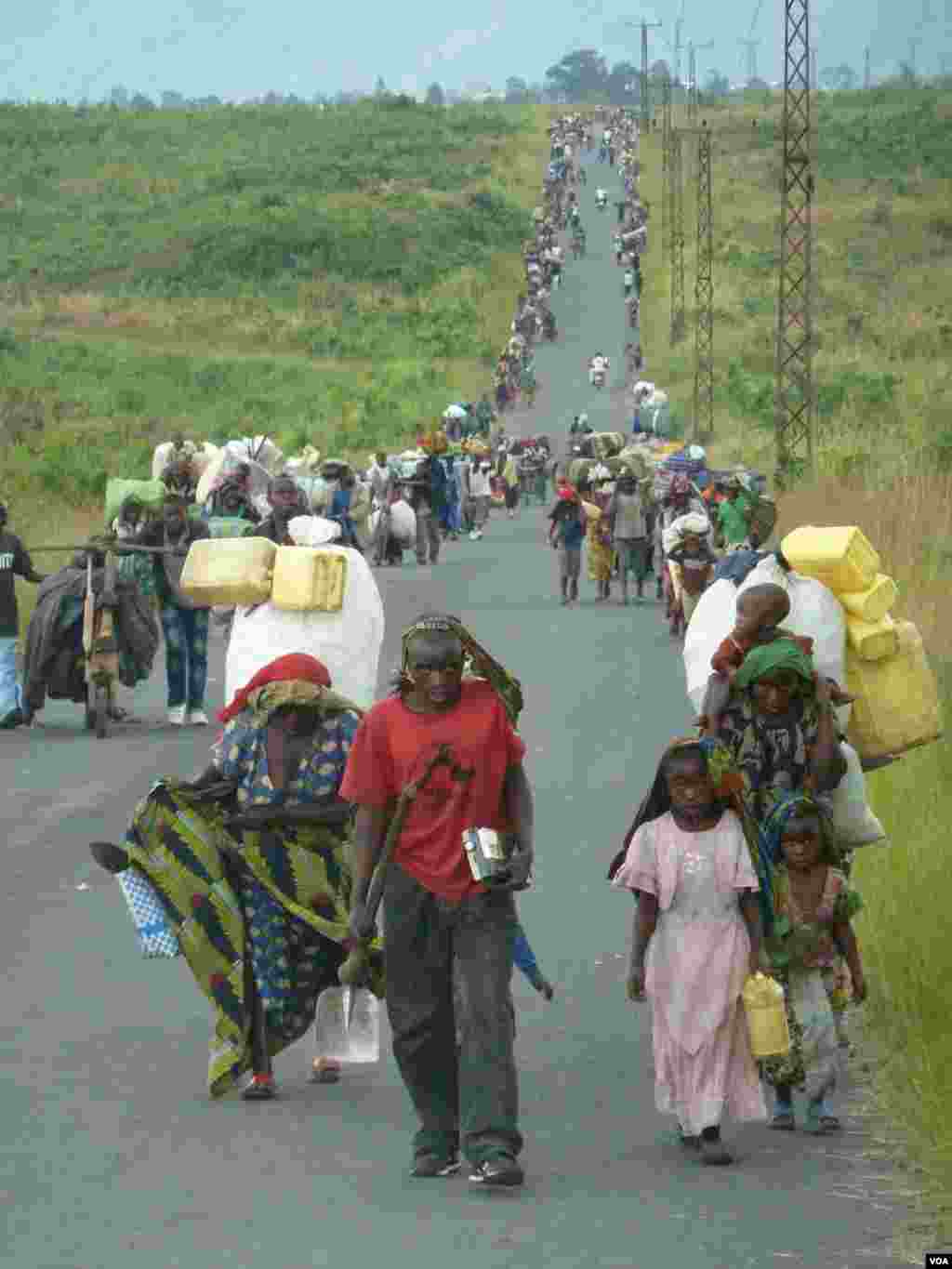刚果政府军和&ldquo;3月23日运动&rdquo;（M23）反政府武装在萨凯镇交战，人们拖家带口逃离战火。（2012年11月23日，美国之音乔洛斯拍摄）