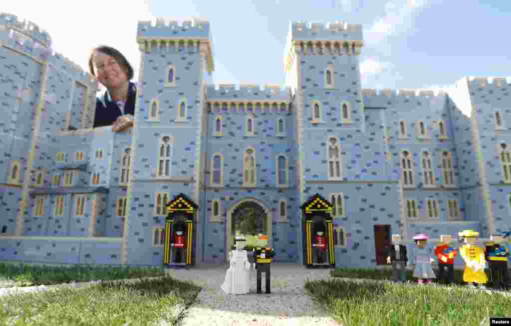 Head model maker, Paula Laughton, poses for a photograph with a LEGO Windsor Castle replete with a royal wedding scene between Britain's Prince Harry and Meghan Markle, in Windsor, England.