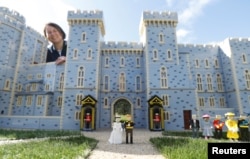 Head model maker, Paula Laughton poses for a photograph with a LEGO Windsor Castle replete with royal wedding between Britain's Prince Harry and Meghan Markle, in Windsor, Britain May 10, 2018.