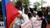 Widnay Charles, left, bows his head during a vigil to commemorate the seventh anniversary of the earthquake that devastated Haiti in 2010, Jan. 12, 2017, in the Little Haiti neighborhood of Miami.