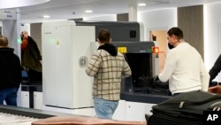 Passengers walk next to Nuctech security scanners at the Brussels Eurostar train terminal on Jan. 17, 2022.