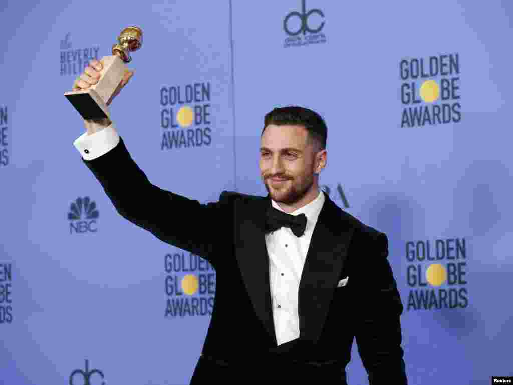 Actor Aaron Taylor-Johnson holds the award for Best Performance by an Actor in a Supporting Role in any Motion Picture for his role in "Nocturnal Animals" during the 74th Annual Golden Globe Awards, Jan. 8, 2017.