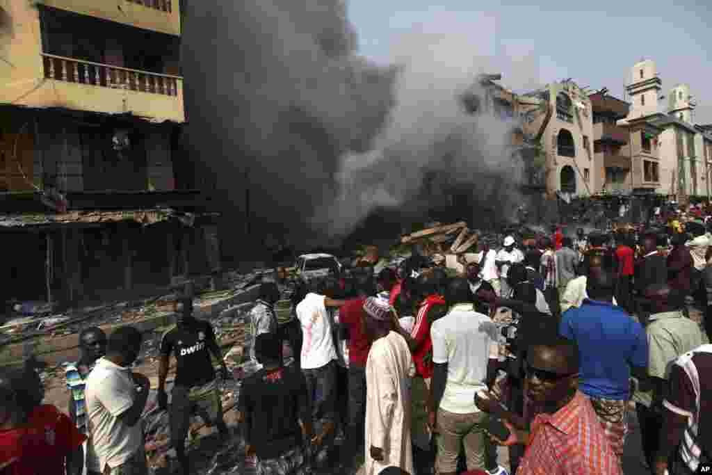 Residents look as a fire burns out a residential homes and a warehouse on Lagos Island in Lagos, Nigeria, December 26, 2012. 