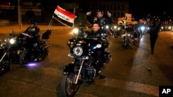 Iraqi bikers take part in a celebration after the lifting of the night-time curfew, at Tahrir Square in Baghdad, Feb. 5, 2015.