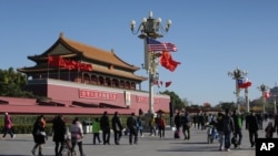 A U.S. flag is displayed beside a Chinese flag as tourists flock outside the Forbidden City in Beijing, Nov. 12, 2014. 