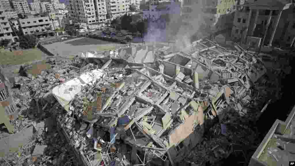 Smoke rises from the rubble of the Al-Zafer apartment tower following Israeli airstrikes Saturday that collapsed the 13-story building, in Gaza City, Sunday, Aug. 24, 2014.