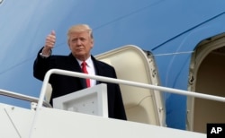 President Donald Trump gives a thumbs up from the top of the steps of Air Force One at Andrews Air Force Base in Maryland, Feb. 17, 2017.