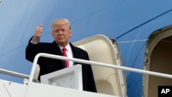 President Donald Trump gives a thumbs up from the top of the steps of Air Force One at Andrews Air Force Base in Md., Feb. 17, 2017.