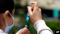 FILE - A shot of the Pfizer COVID-19 vaccine is prepared at the First Baptist Church of Pasadena, Calif., May 14, 2021.