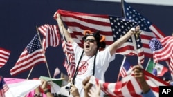 FILE — A man waves an American flag during a during a rally in Atlanta, Georgia.