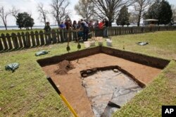 Experts inform visitors at the dig site of the Angelo slave house in Jamestown, Va., April 10, 2018.