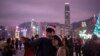 A couple clad in Santa hats pose for a selfie as the city skyline is seen along Hong Kong's Victoria Harbor, Dec. 25, 2018.