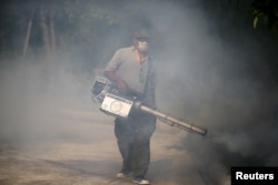 FILE - A worker sprays insecticide for mosquitos at a village in Bangkok, Thailand, Jan. 13, 2016.
