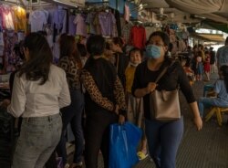 FILE - A woman wearing mask walks pass by a cloth store in Central Market in Phnom Penh, Cambodia on June 11, 2020. (Malis Tum/VOA Khmer)