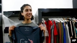 Palestinian-American Yasmeen Mjalli holds one of her T-shirt designs with the slogan "Not Your Habibti (darling)."