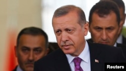 Turkish President Tayyip Erdogan (C) looks on after arriving at Esenboga Airport, in Ankara, June 8, 2015. 