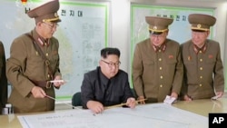 FILE - This image made from video of an Aug. 14, 2017, still image broadcast in a news bulletin, Aug. 15, 2017, by North Korea's KRT shows North Korean leader Kim Jong Un receiving a briefing in Pyongyang.