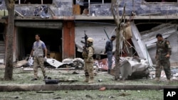 Security personnel investigate the site of a suicide attack that struck the convoy of presidential candidate Abdullah Abdullah in Kabul, June 6, 2014. 