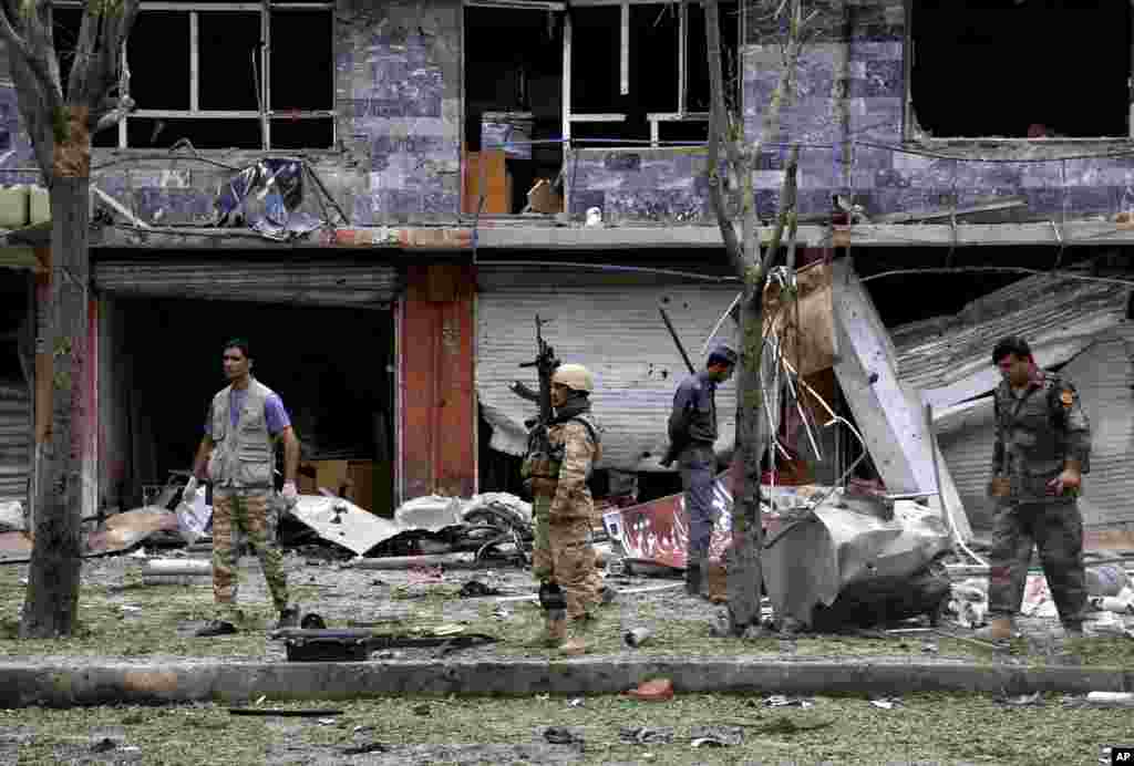 Security personnel investigate the site of a suicide attack that struck the convoy of presidential candidate Abdullah Abdullah in Kabul, June 6, 2014. 