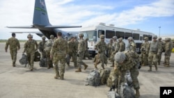 En esta foto provista por la Fuerza Aérea de EE.UU., elementos de la policía militar y del batallón de ingeniería llegan al Fuerte Ruley, en Kansas, el 1 de noviembre de 2018. 