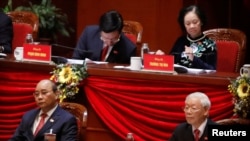Vietnam's President and General Secretary of the Communist Party Nguyen Phu Trong (R, bottom) and Prime Minister Nguyen Xuan Phuc (L, bottom) attend the closing ceremony of the 13th national congress of the ruling communist party of Vietnam at the National Convention Center in Hanoi, Vietnam February 1, 2021. The Vietnamese communist party has been greatly enforcing its laws against political disapproval messages online in recent years through social media sites like Facebook. (REUTERS/Kham)