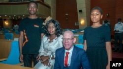 Former President for the Association of People with Albinism in Malawi, Overstone Kondowe (2nd L), poses with his wife Memory (2nd R), and their children, Promise (L), and Ellen (R), in Malawi's parliament on November 4, 2021.