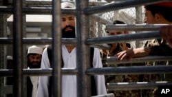 Un prisionero afgano aguarda en fila ser liberado de Parwan luego del traspaso de mando en la cárcel.