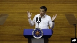 Philippine President Rodrigo Duterte, center, gestures watched by Senate President Aquilino "Koko" Pimentel III, left, and Speaker Pantaleon Alvarez during his second state of the nation address at the House of Representatives in suburban Quezon city, nor