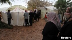Syrian refugees put up donated new tents after their previous ones where damaged in a storm in Tripoli, Lebanon, Jan. 9, 2013
