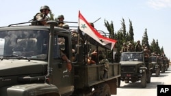 In this photo taken during a government-organized visit for media, Syrian army soldiers ride on their military trucks as they enter the villages near the town of Jisr al-Shughour, north of Damascus, June 10, 2011