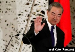 Menteri Luar Negeri China Wang Yi melambaikan tangan ketika ia meninggalkan konferensi pers di Tokyo, Jepang, pada 24 November 2020. (Foto: Reuters/Issei Kato/Pool)