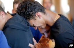 Austin Burden, 17, cries on the shoulder of a friend after a vigil at the Parkland Baptist Church, for the victims of the Wednesday shooting at Marjory Stoneman Douglas High School, in Parkland, Fla., Feb. 15, 2018.