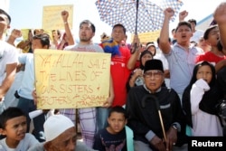 Mantan Sultan Sulu Jamalul Kiram III (duduk di kanan) bersama para pengikutnya memasang plakat di depan Masjid Biru di desa Maharlika, kota Taguig, selatan Manila, 1 Maret 2013. (Foto: Reuters)