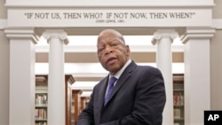 Rep. John Lewis, D-Ga., poses for a photograph under a quote of his that is displayed in the Civil Rights Room in the Nashville Public Library Friday, Nov. 18, 2016, in Nashville, Tenn. 