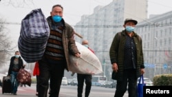 中国举行两会的周三，人们行走在北京市中心。（2021年3月10日）