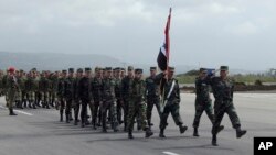 In this photo provided by the Russian Defense Ministry Press Service, Syrian troops march during a send-off ceremony for Russian troops at Hemeimeem air base in Syria, March 15, 2016.