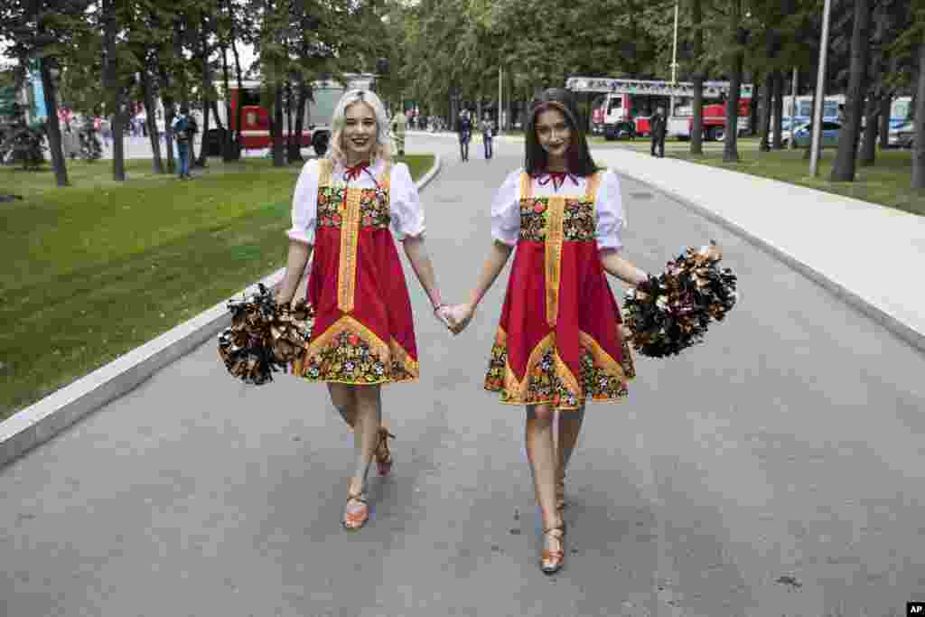 قدم زدن این دو خانم که لباس سنتی روسیه را نیز بر تن دارند از مقابل ورزشگاه لوژنیکی، محل برگزاری اولین دیدار از مسابقات فوتبال جام جهانی ۲۰۱۸ بین دو تیم&nbsp; روسیه و عربستان سعودی.