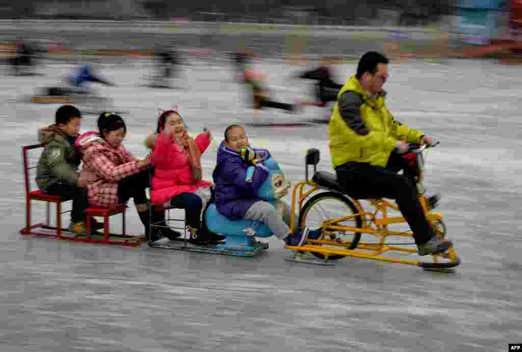 Chinese visitors enjoy sledding and skating on the partially frozen Houhai Lake during the Lunar New Year holiday in Beijing. 