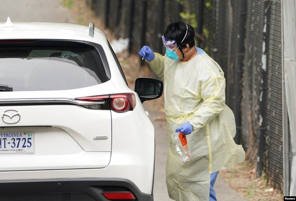 Un trabajador de la salud toma una muestra de un pasajero en un sitio de tránsito temporal para recolectar muestras para la prueba de coronavirus en Arlington, Virginia, EE. UU.