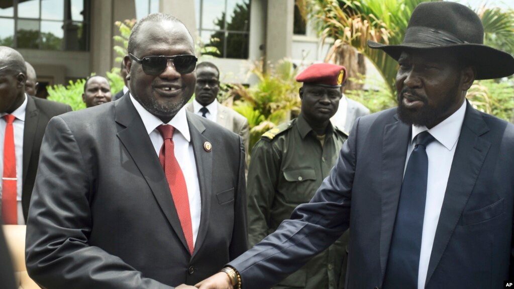 FILE - Riek Machar, left, and President Salva Kiir shake hands following the first meeting of a new transitional coalition government, in Juba, South Sudan, April 29, 2016. 