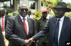 FILE - South Sudan's First Vice President Riek Machar (L) and President Salva Kiir (R) shake hands following the first meeting of a new transitional coalition government, in the capital Juba, South Sudan, April 29, 2016.