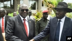 FILE - South Sudan's then-First Vice President Riek Machar (L) and President Salva Kiir (R) shake hands following the first meeting of a new transitional coalition government, in the capital Juba, South Sudan, April 29, 2016. 