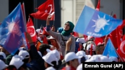 Supporters listen to Turkey's Prime Minister and leader of the ruling Justice and Development Party, Ahmet Davutoglu, as he addresses a rally before the Nov. 1 general elections, in Bursa, Turkey.