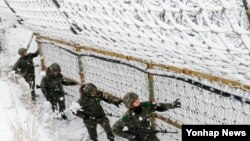 14일 한국 강원도 중동부전선을 지키는 15사단 장병들이 눈 쌓인 철책에서 경계작전을 강화하고 있다. (자료사진)