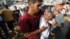 在加沙地带南部，巴勒斯坦人搜寻被埋在废墟下的亲人。