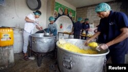 Cooks pack food at a charity kitchen that gives free food rations for the poor, in Sanaa, Yemen, April 20, 2018.