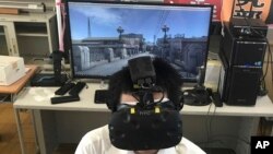 Namio Matsura, a member of the computation skill research club at Fukuyama Technical High School, watches Hiroshima city before atomic bomb fell in virtual reality experience at the high school in Hiroshima, western Japan. (AP Photo/Haruka Nuga)