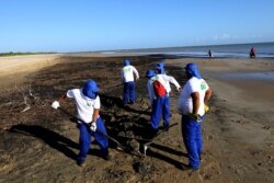 Workers remove oil from Viral Beach, in Aracaju, Brazil, Oct. 8, 2019. The oil that has been polluting Brazil's northeastern beaches since early September is likely coming from Venezuela, according to a report by Brazil's state oil company.